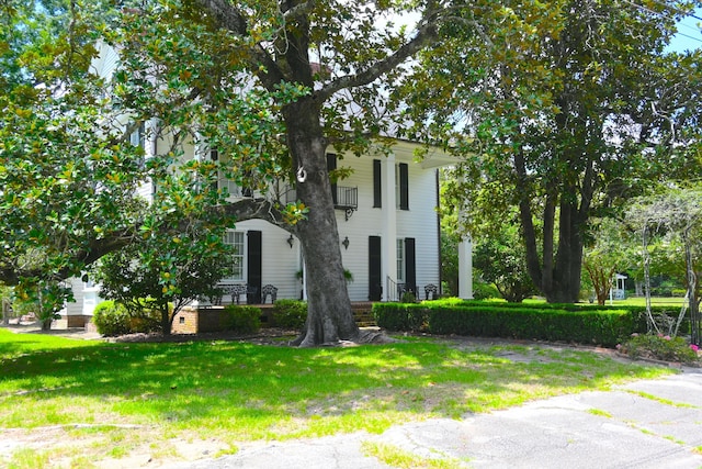 neoclassical home featuring a front lawn