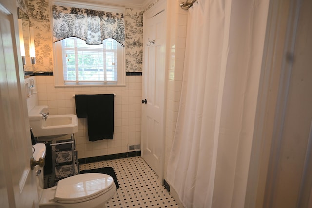 full bathroom featuring visible vents, a wainscoted wall, toilet, tile walls, and wallpapered walls