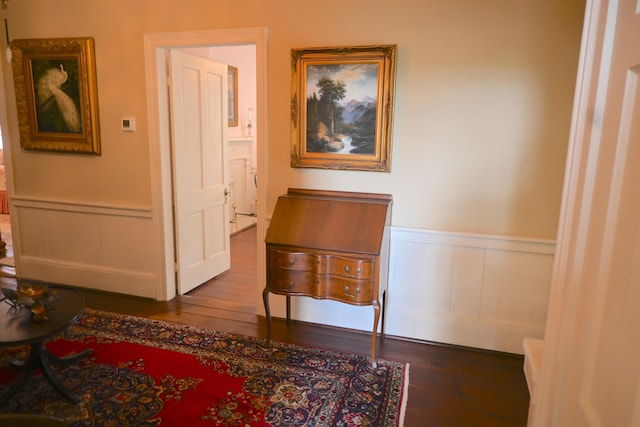 living area with wood finished floors and wainscoting
