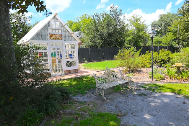 view of yard with an outbuilding, an exterior structure, and fence