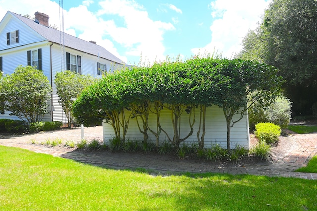 view of home's exterior with a lawn and a chimney