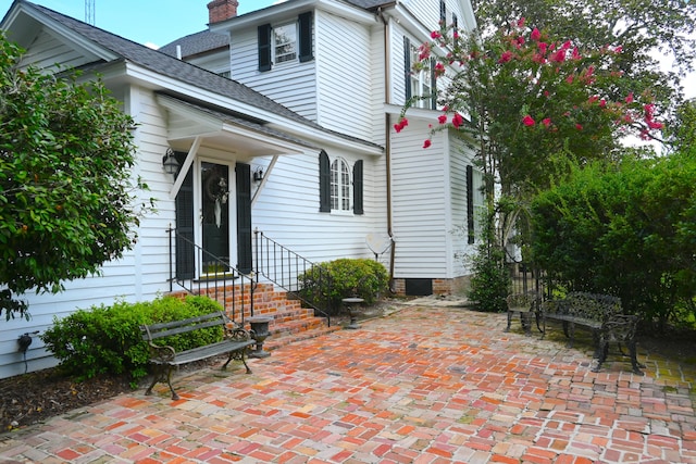 exterior space featuring roof with shingles and a chimney