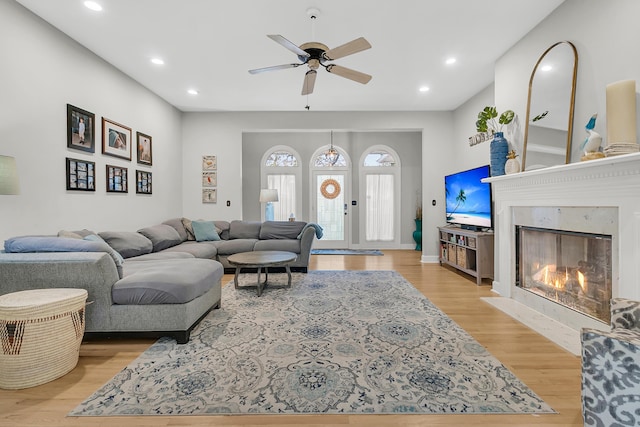 living area with recessed lighting, a fireplace, a ceiling fan, and wood finished floors