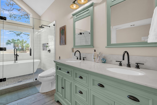 bathroom with double vanity, a freestanding tub, vaulted ceiling, and a sink