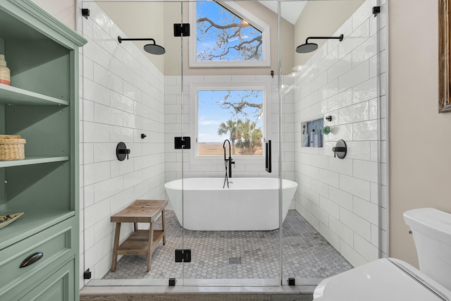 bathroom with tile patterned flooring, a shower stall, toilet, and tile walls