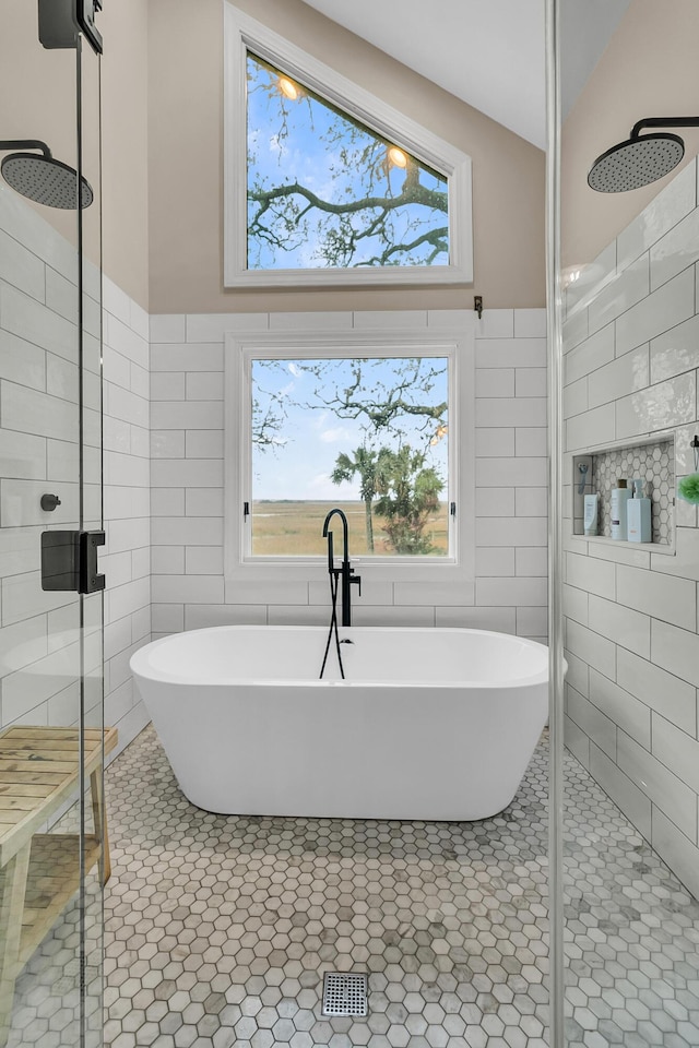 full bathroom with a soaking tub, tile walls, a stall shower, and tile patterned flooring