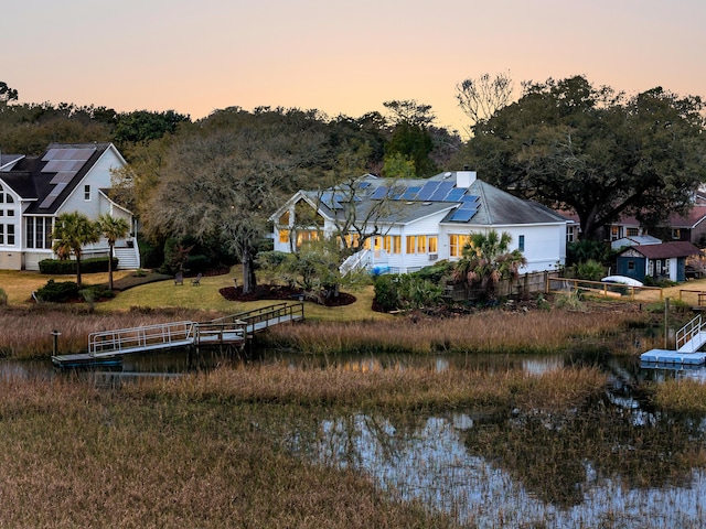 exterior space featuring a water view and roof mounted solar panels