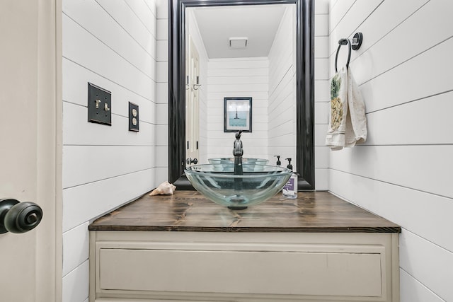 bathroom with wooden walls and vanity