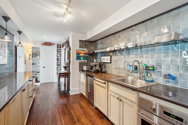 kitchen with sink, decorative light fixtures, stainless steel appliances, dark hardwood / wood-style floors, and decorative backsplash