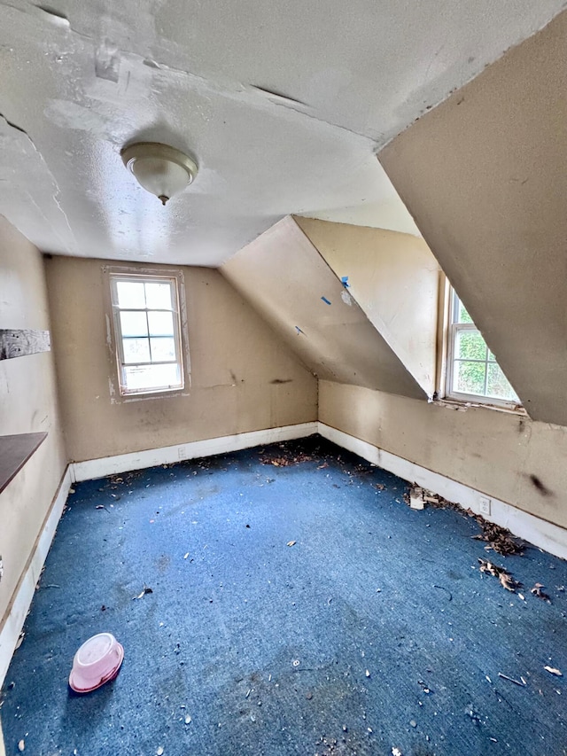 bonus room with a textured ceiling and vaulted ceiling