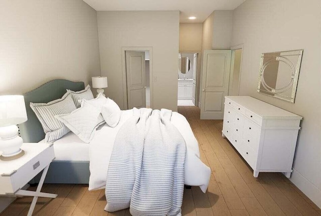 bedroom with light hardwood / wood-style floors and ensuite bath