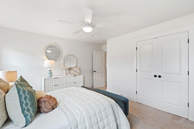 bedroom featuring ceiling fan, light colored carpet, and a closet