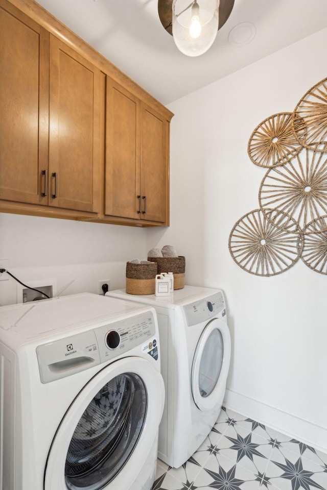 washroom with washing machine and dryer and cabinets