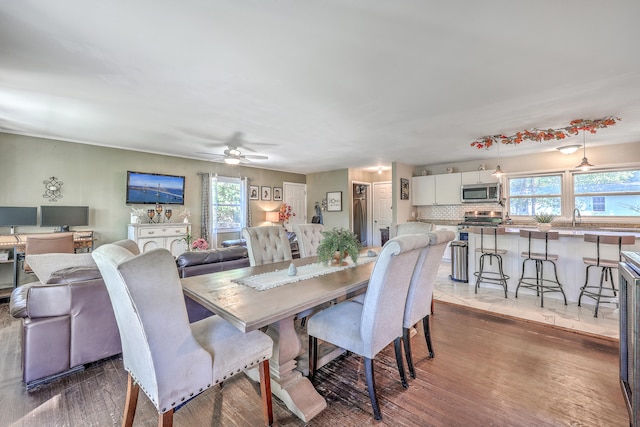 dining space with a wealth of natural light, sink, ceiling fan, and dark wood-type flooring