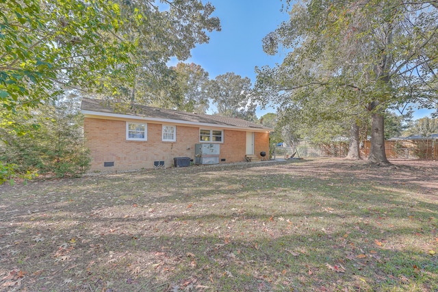 back of house with a yard and central AC