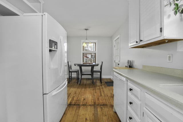 kitchen featuring white appliances, decorative light fixtures, dark hardwood / wood-style flooring, and white cabinets