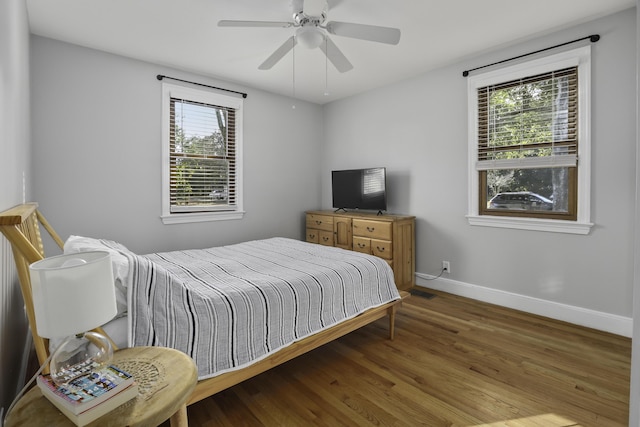 bedroom with ceiling fan, hardwood / wood-style floors, and multiple windows