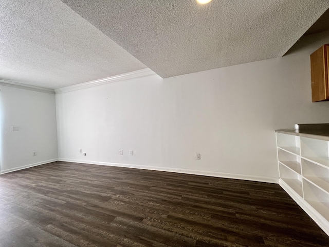 spare room with dark hardwood / wood-style flooring, a textured ceiling, and ornamental molding