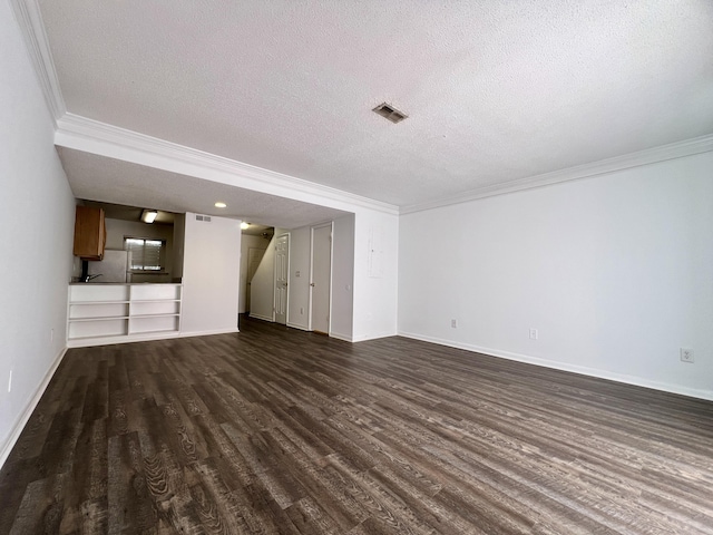 unfurnished living room featuring dark hardwood / wood-style flooring, a textured ceiling, and ornamental molding