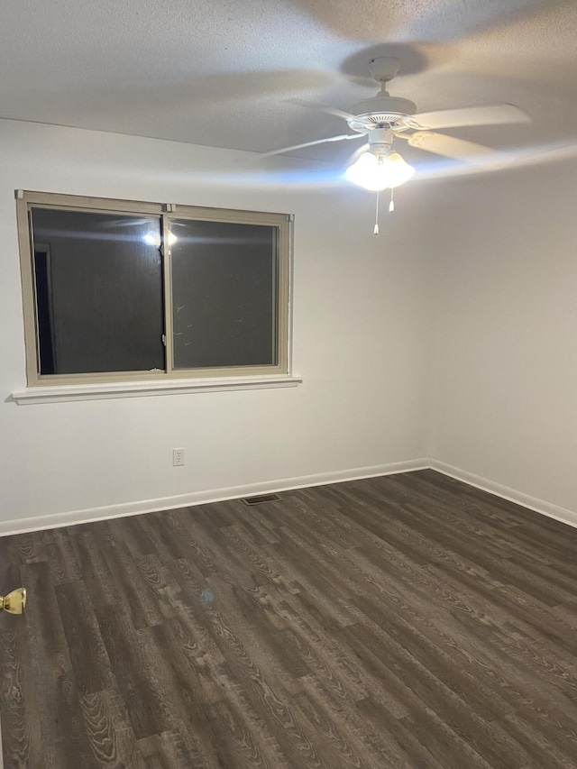 spare room featuring dark hardwood / wood-style flooring, a textured ceiling, and ceiling fan