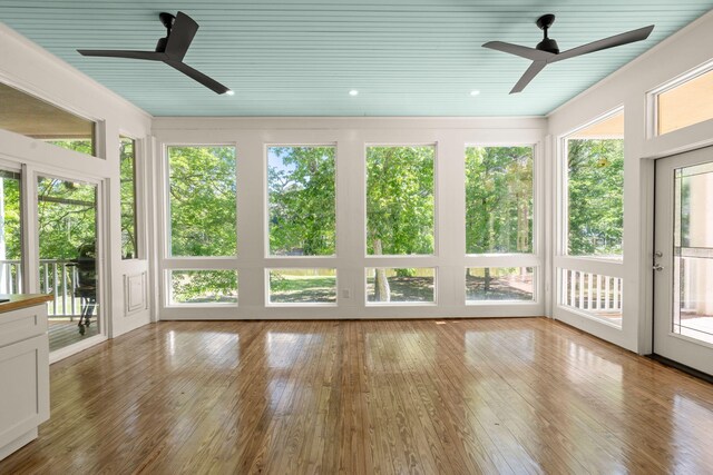 unfurnished sunroom featuring healthy amount of natural light, wood-type flooring, and wood ceiling
