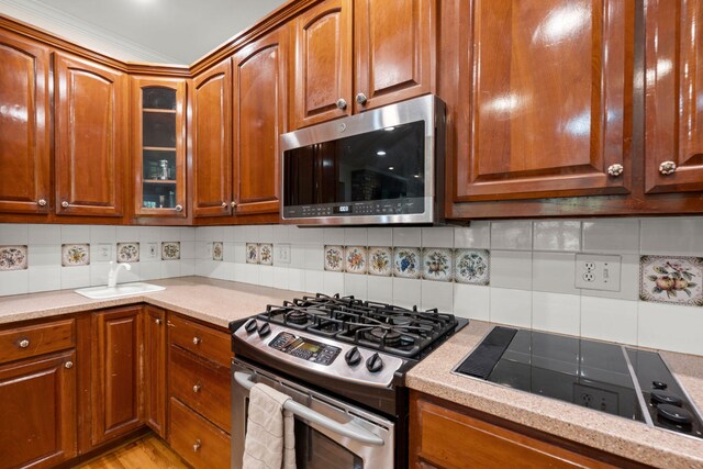 kitchen with appliances with stainless steel finishes, glass insert cabinets, backsplash, and brown cabinets