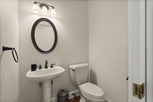 bathroom featuring baseboards and toilet