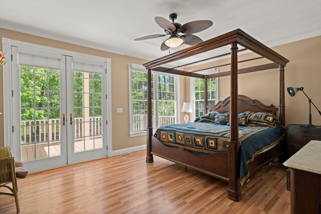bedroom featuring access to outside, wood finished floors, multiple windows, crown molding, and baseboards