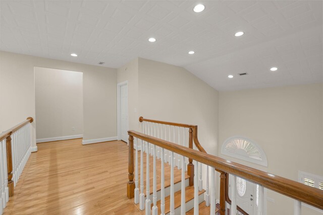 hallway featuring an upstairs landing, light wood finished floors, recessed lighting, and baseboards