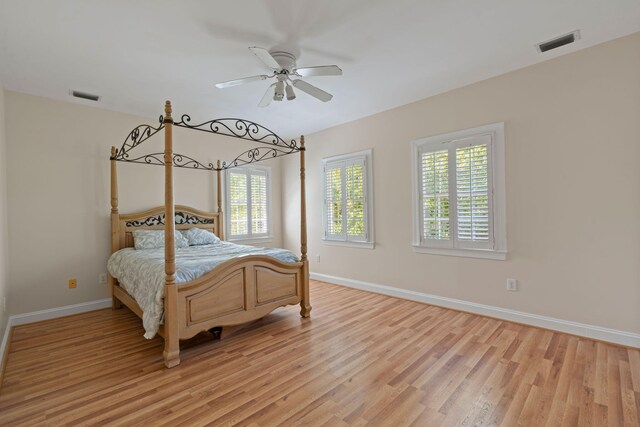 bedroom featuring light wood-type flooring, baseboards, and a ceiling fan