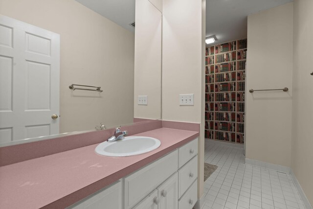 bathroom with tile patterned floors, vanity, and baseboards