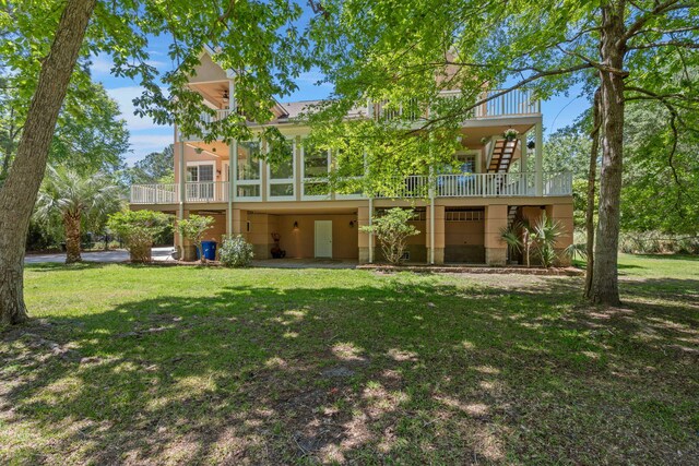 rear view of property with a lawn, stucco siding, and a balcony