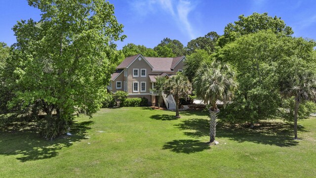 view of front of property featuring stairs, a front lawn, and a shingled roof