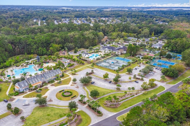 aerial view of property's location featuring a pool and a forest