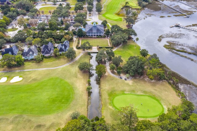 aerial view of property and surrounding area with a golf course, nearby suburban area, and a large body of water