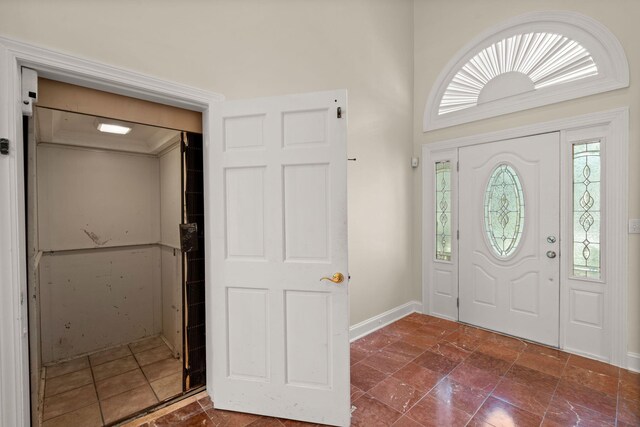 entryway featuring healthy amount of natural light, baseboards, and dark stone finish flooring