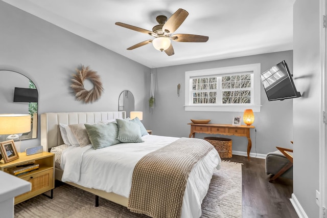 bedroom with ceiling fan, wood finished floors, and baseboards