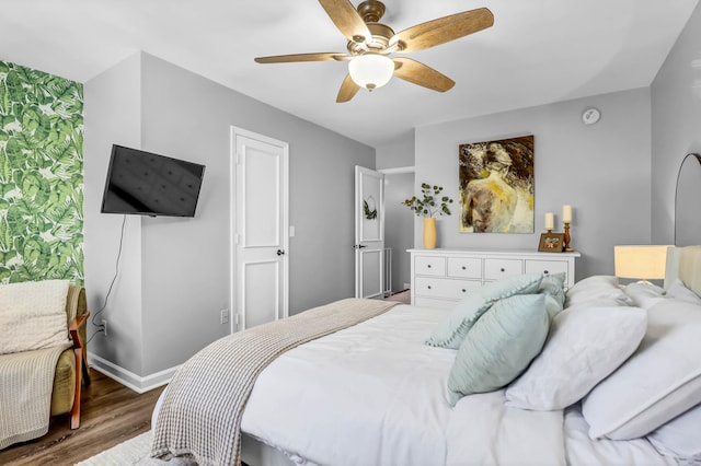 bedroom with ceiling fan, baseboards, and wood finished floors