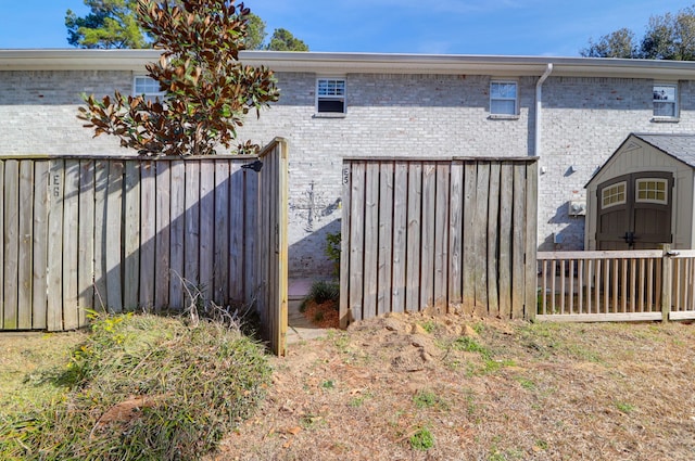 exterior space with fence, a storage unit, and an outdoor structure