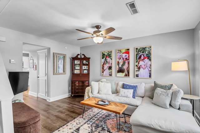 living area featuring a ceiling fan, baseboards, visible vents, and wood finished floors