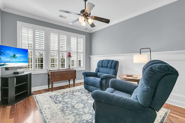 living area featuring ornamental molding, ceiling fan, and wood-type flooring