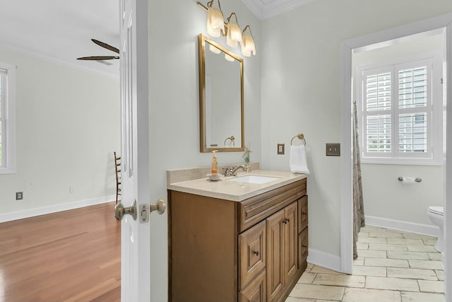 bathroom featuring ceiling fan, crown molding, vanity, and toilet