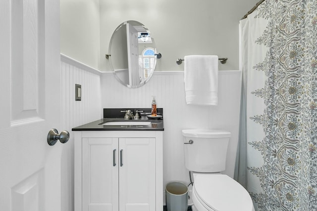 bathroom featuring toilet, vanity, and curtained shower