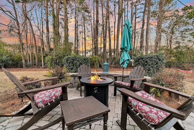 patio terrace at dusk featuring an outdoor fire pit