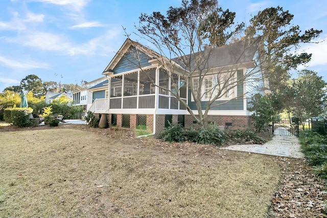 back of property featuring a lawn and a sunroom