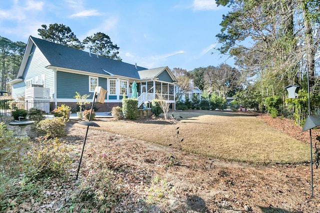 rear view of property featuring a sunroom