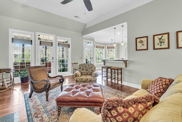 living room featuring ornamental molding, ceiling fan, and wood-type flooring