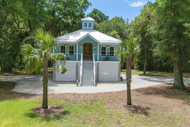 16 Oakwood Ln, Edisto Island, SC 29438 - coastal inspired home with french doors, stairway, a porch, a metal roof, and a front lawn