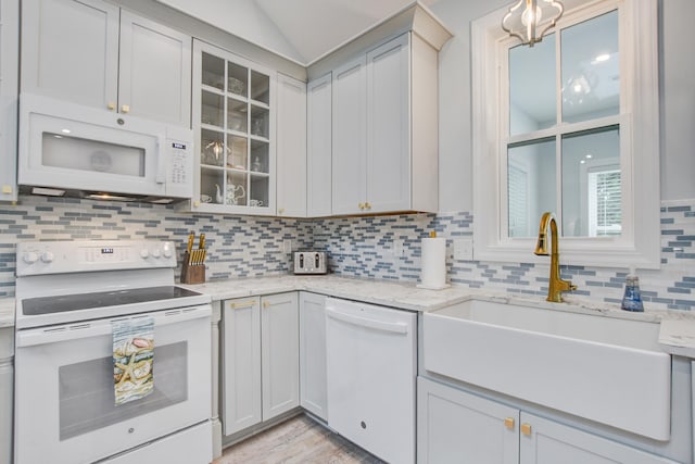 16 Oakwood Ln, Edisto Island, SC 29438 - kitchen featuring white appliances, backsplash, glass insert cabinets, light stone countertops, and lofted ceiling
