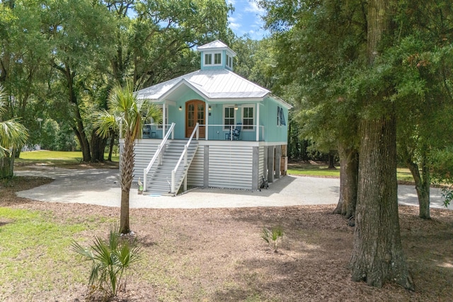 16 Oakwood Ln, Edisto Island, SC 29438 - coastal inspired home featuring stairs, a porch, french doors, a metal roof, and driveway